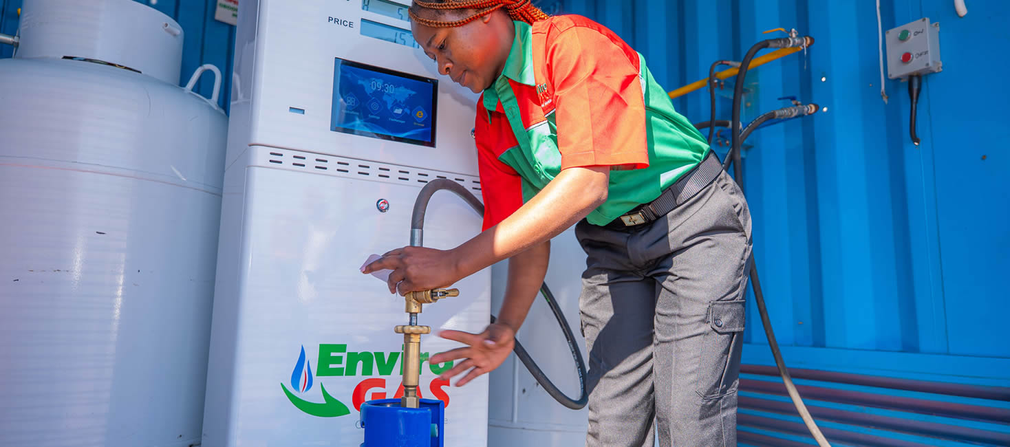 EnviroGas attendant dispensing gas at a branded prepaid station